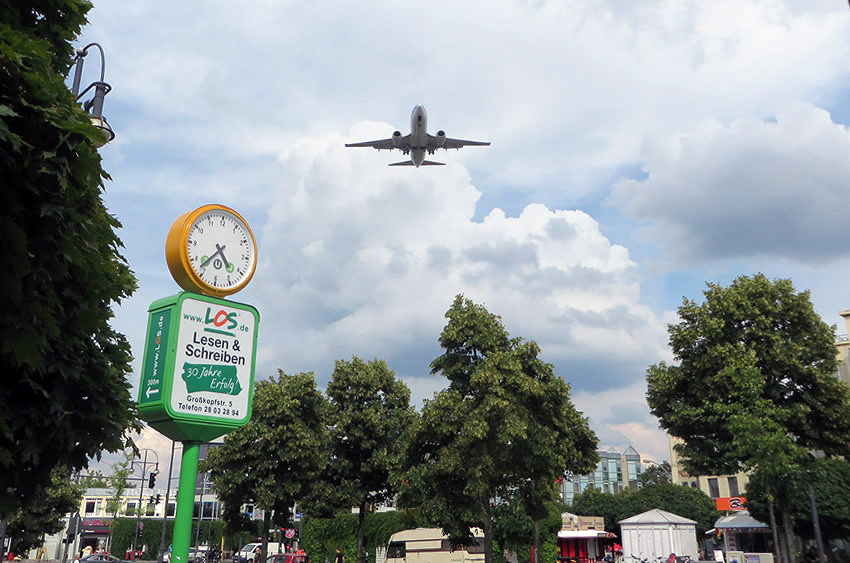 Aeroplanes soar over the heads of shoppers at Berlin's Kurt-Schumacher-Platz